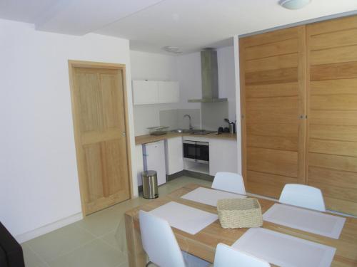 - une cuisine avec une table et des chaises blanches dans la chambre dans l'établissement La Ferronnerie Cassis centre, à Cassis