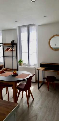 - un salon avec une table, des chaises et un piano dans l'établissement Le Saint-Alpin, à Châlons-en-Champagne