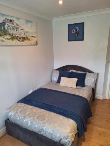 a bedroom with a bed with a blue bedspread at Cosy Gated Room with Free Secure Parking Private Bathroom in Woking