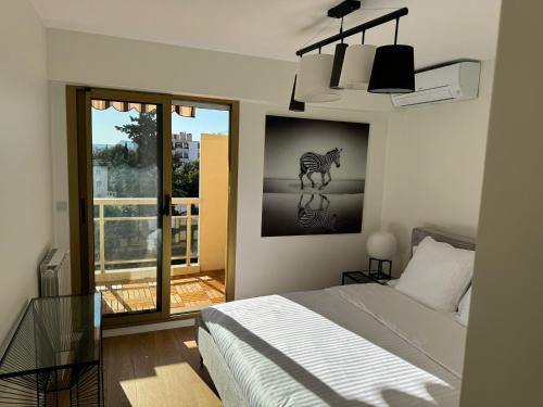 - une chambre avec un lit et une photo d'un zèbre dans l'établissement Appartement L'ECRIN DES EMPEREURS, à Saint-Raphaël