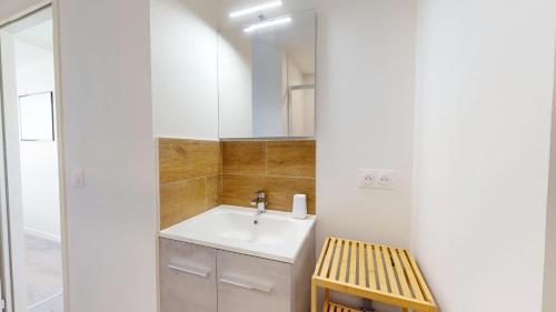 une salle de bain avec un lavabo et un miroir dans l'établissement Le Nid de la Mouette, à Saint-Hilaire-de-Riez