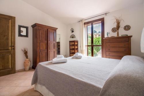 Un dormitorio con una cama grande con toallas. en GuestHost - Comfy Apartment X3 with Terrace, en San Pantaleo