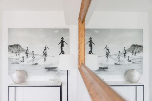 a mirror on a wall with a picture of people surfing at Outstanding Apartment-Near Disneyland Paris in Chessy
