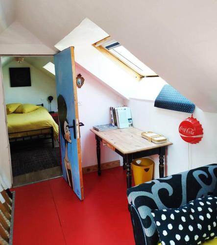 Cette chambre comprend une table et un lit. dans l'établissement atelier d artiste au bord de l eau, à Plérin