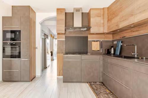 une cuisine avec des appareils en acier inoxydable et des armoires en bois dans l'établissement Maison Rosy, à Carcassonne