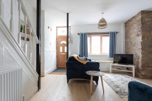 a living room with a blue couch and a tv at Fisherman's Cottage by the sea in Morecambe