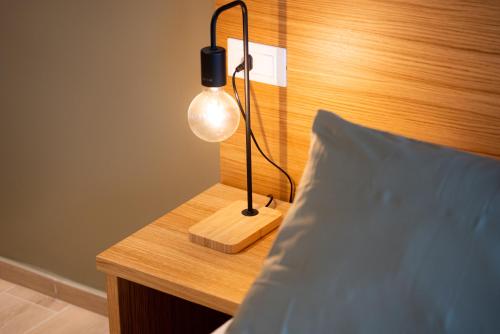 a lamp sitting on a desk next to a bed at Locanda 19 al paradiso in Mirano