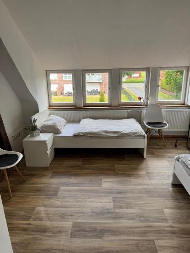 a bedroom with a bed and two windows at MonteurGut Apartments Birke in Lindern