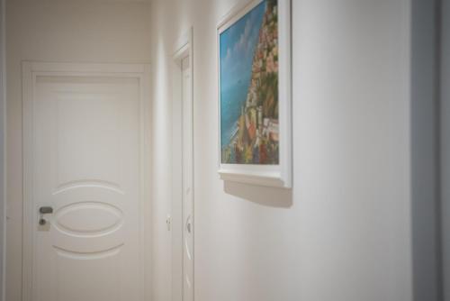a white door with a painting on the wall at Locanda 19 al paradiso in Mirano