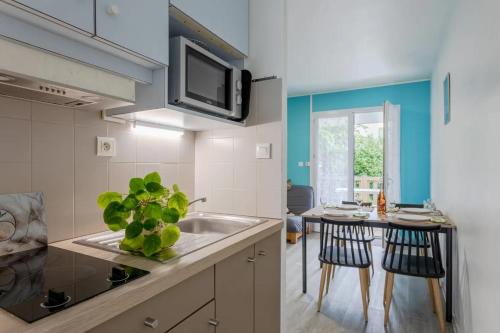 une cuisine avec un évier et une table avec des chaises dans l'établissement Studio Confort, à Maché