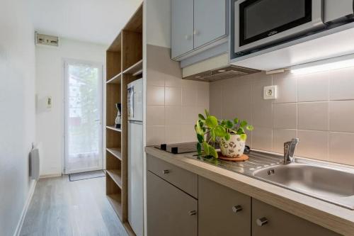 une cuisine avec un évier et un comptoir dans l'établissement Studio Confort, à Maché