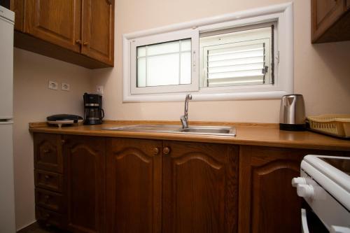 a kitchen with a sink and a window at Dagos Rooms in Dhërmi