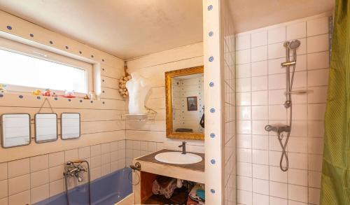 une salle de bain avec un lavabo, un miroir et une douche dans l'établissement atelier d artiste au bord de l eau, à Plérin