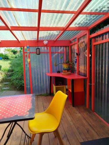 une maison avec une table et une chaise jaune sur une terrasse dans l'établissement atelier d artiste au bord de l eau, à Plérin