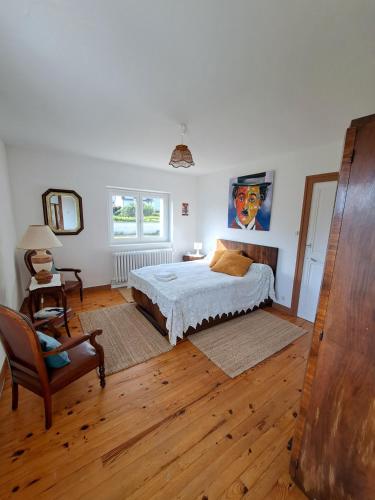 une chambre avec un lit et une chaise dans l'établissement Chez Patrice et Marieline F2, à Usson-en-Forez