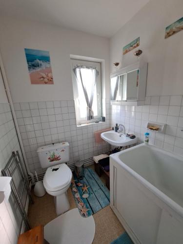une salle de bain avec toilettes, lavabo et baignoire dans l'établissement Chez Patrice et Marieline F2, à Usson-en-Forez