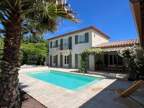 une villa avec piscine devant une maison dans l'établissement Bastide de charme, élégance, calme et sérénité, à Saint-Drézéry