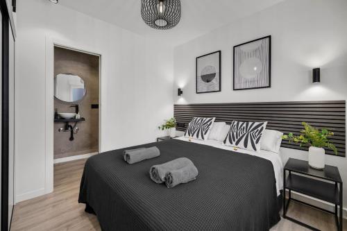a bedroom with a large bed with two pillows on it at Las Flores Luxury Apartment in Málaga