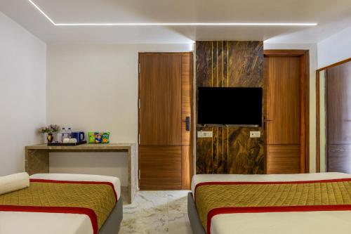a hotel room with two beds and a flat screen tv at Hotel All In Homes - New Delhi Railway station- Paharganj in New Delhi