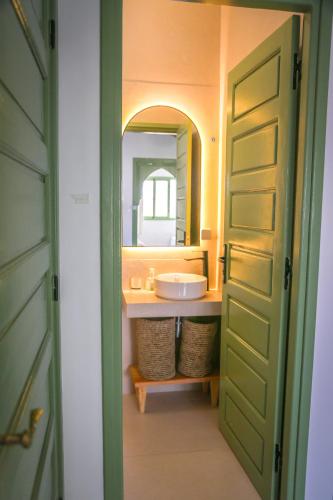 a bathroom with a sink and a mirror at Appartement chic et beldi à 10 minutes du centre in Essaouira