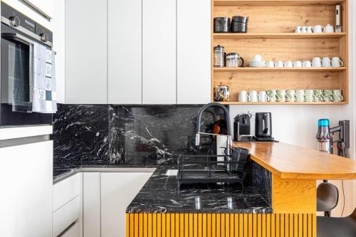 une cuisine avec des armoires blanches et un comptoir en bois dans l'établissement GuestReady - Parisian charm near Notre-Dame, à Paris