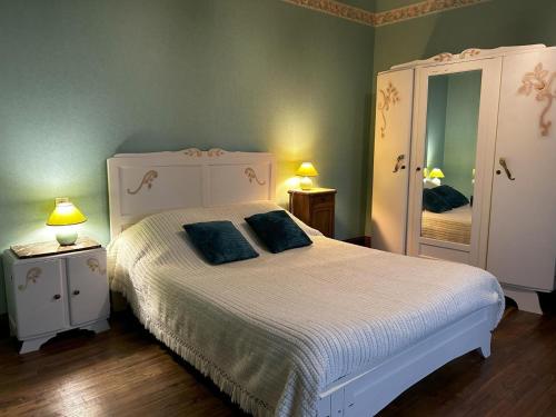 a bedroom with a white bed with two blue pillows at Les petites chaumes in Champagné-le-Sec