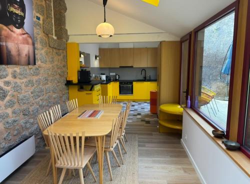 une cuisine avec des armoires jaunes et une table et des chaises en bois dans l'établissement La Pagode, à Trégastel