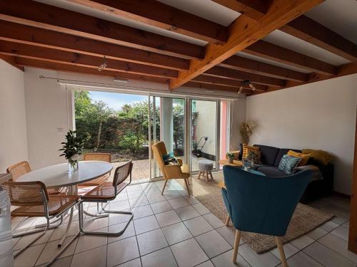 un salon avec une table et des chaises dans l'établissement Maison mitoyenne avec beau jardin proche lac, à Biscarrosse