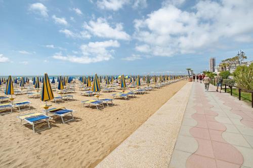 a row of chairs and umbrellas on a beach at Relaxing Sea View in Lido di Jesolo