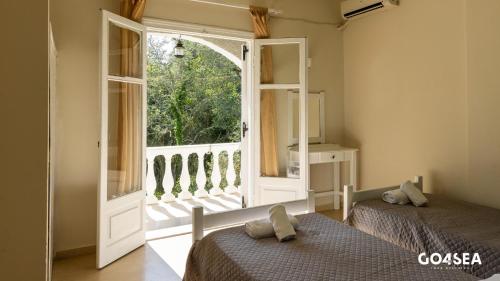 a bedroom with two beds and a large window at Neos Alexandros by Go4sea in Kato Korakiana