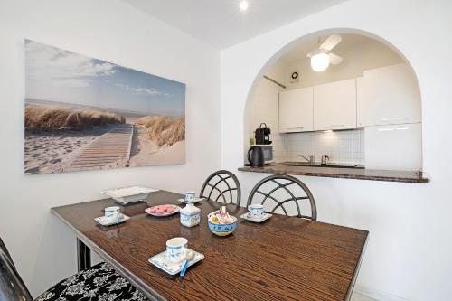 a kitchen and dining room with a wooden table and chairs at Relaxing Sea View in Lido di Jesolo