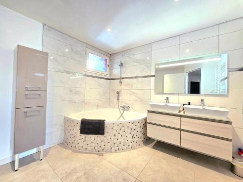 une salle de bain avec une baignoire et un lavabo dans l'établissement Ker El-Rapha - Calme & confort familiale en ville, à Saint-Avé