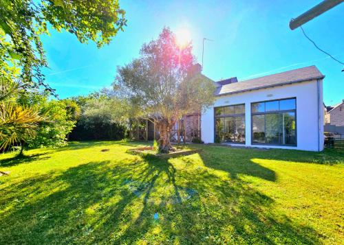 une maison avec un arbre dans la cour dans l'établissement Ker El-Rapha - Calme & confort familiale en ville, à Saint-Avé