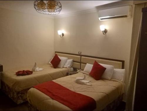 a hotel room with two beds with red and white pillows at Town View Hotel in Cairo