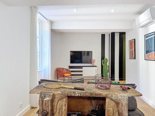 - un salon avec une table en bois et une télévision dans l'établissement Toulouse - Capitole appartement à thème, à Toulouse