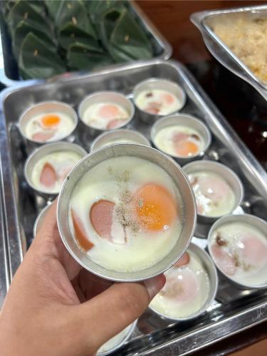 a person holding a cup of food in a tray of food at Sun-San Thalane Resort in Ban Laem