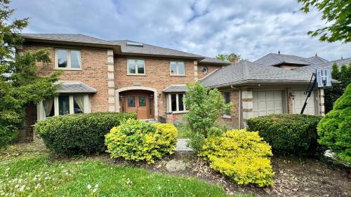 a brick house with bushes in front of it at Massive Luxury Retreat with Gym, Sauna, Games and More in Mississauga