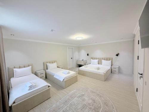 a room with two beds and a rug at Hotel Zamon in Samarkand