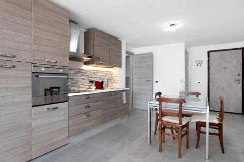 a kitchen with wooden cabinets and a table and chairs at ambra in Aosta
