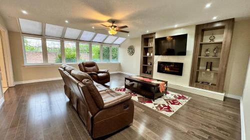 a living room with a couch and chairs and a tv at Massive Luxury Retreat with Gym, Sauna, Games and More in Mississauga