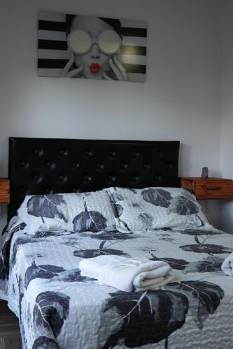 a bedroom with a bed with a black headboard at Hospedaje posada en Ezeiza in Ezeiza