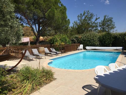 - une piscine avec des chaises longues à côté d'une clôture dans l'établissement Les Oliviers, à Villemoustaussou