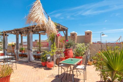 a patio with chairs and tables and potted plants at Riad Dar Alif & SPA in Marrakech