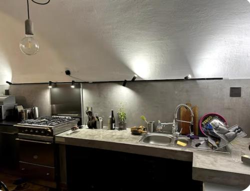 une cuisine avec un évier et une cuisinière dans l'établissement Maison de village atypique A Cappella, à Lumio