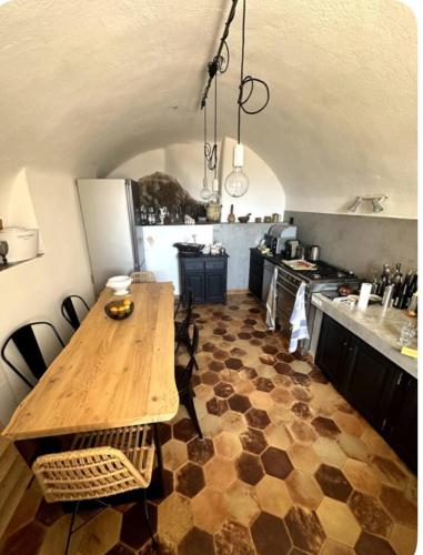 une cuisine avec une table en bois au milieu dans l'établissement Maison de village atypique A Cappella, à Lumio