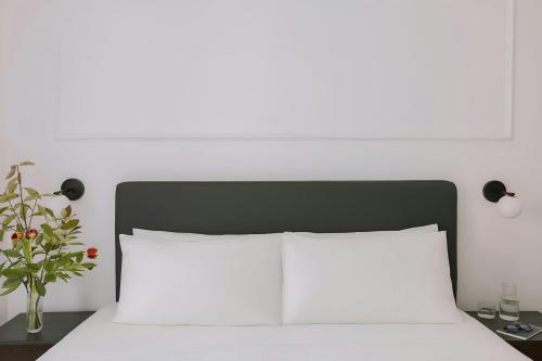 a white bed with a black headboard and a white pillow at Missori Hotel Piazza Missori, Sonder by Marriott Bonvoy in Milan