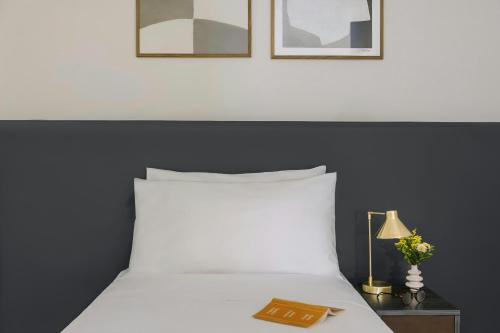 a bedroom with a white bed and a table with a lamp at Missori Hotel Piazza Missori, Sonder by Marriott Bonvoy in Milan