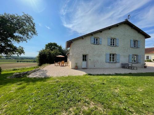 une vue extérieure d'une ferme avec tables et chaises dans l'établissement La Petite Maison, à Lagardère