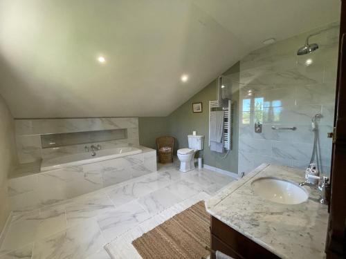 une salle de bain avec un lavabo, une baignoire et des toilettes dans l'établissement La Petite Maison, à Lagardère