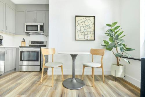 a white kitchen with a table and chairs at Sonder by Marriott Bonvoy The Elm Apartments Downtown in Toronto